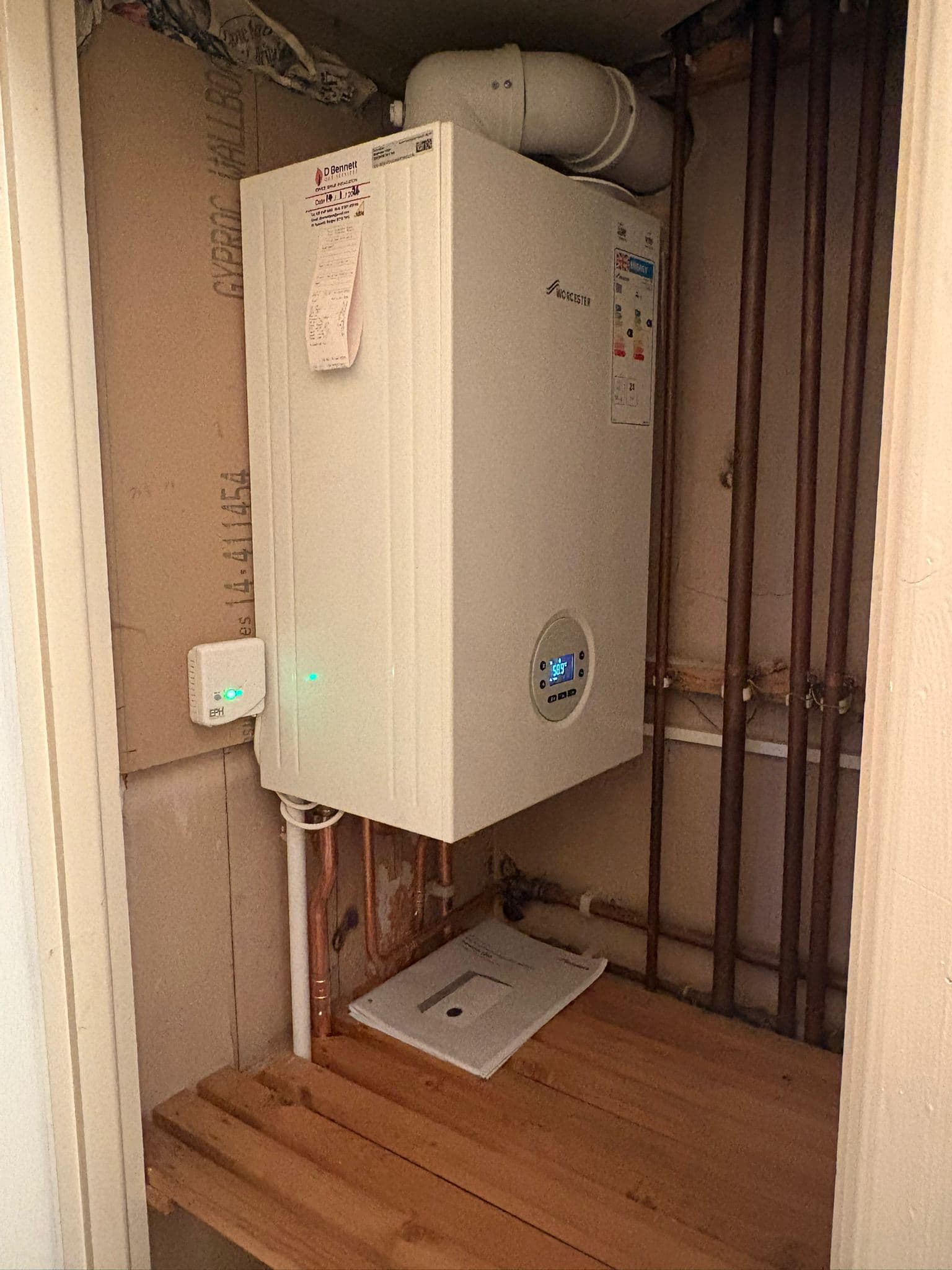 Worcester combi boiler in a domestic cupboard with newly installed wireless thermostat receiver