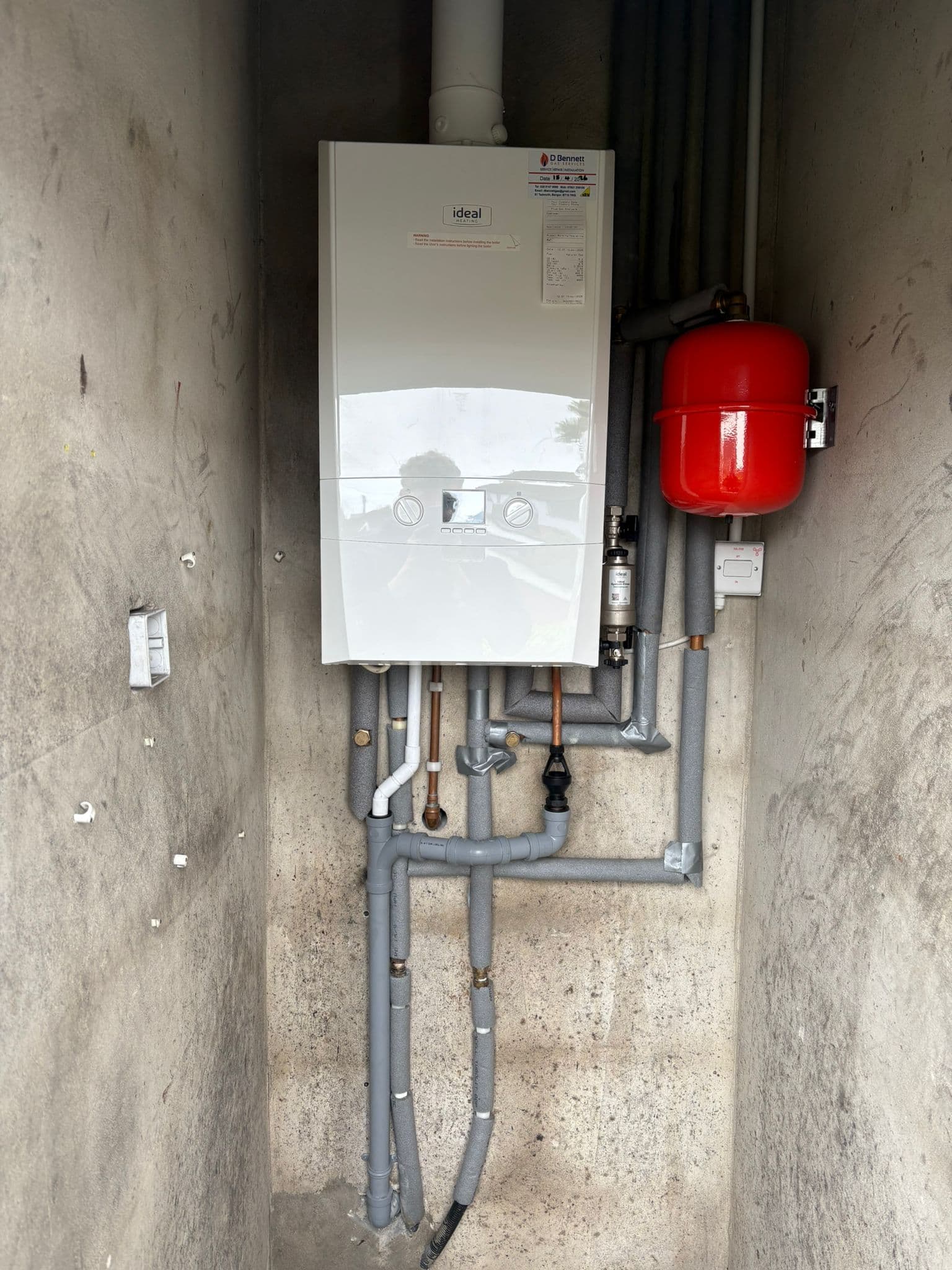Ideal system boiler with red expansion vessel and zoned pipework in a utility space